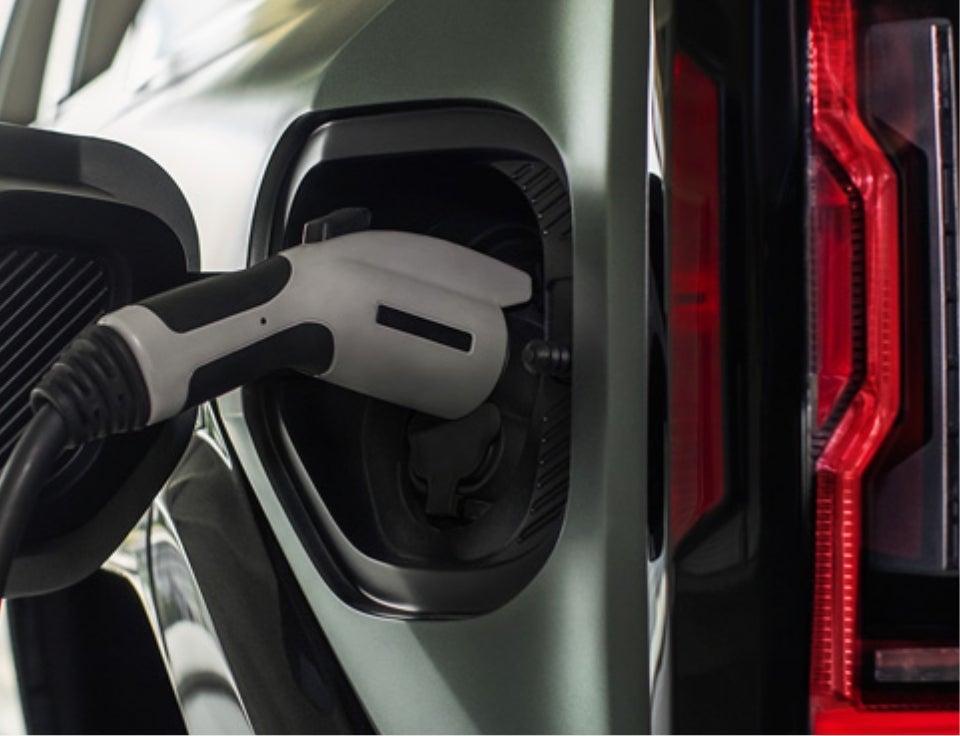Close up of charging port with charger plugged in on a GMC Hummer EV SUV - Growney Motors in RED BLUFF CA